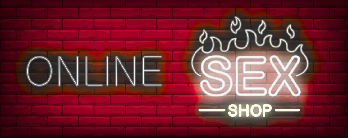 Сексшоп недорогой и сексшоп дешевый sex shop online надпись неоновая светящаяся на фоне красных кирпичей